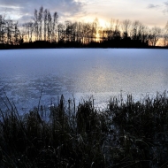 Odraz slunce na zamrzlém Kačerovském rybníce
